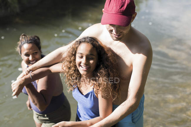 Família feliz brincando no rio — Fotografia de Stock