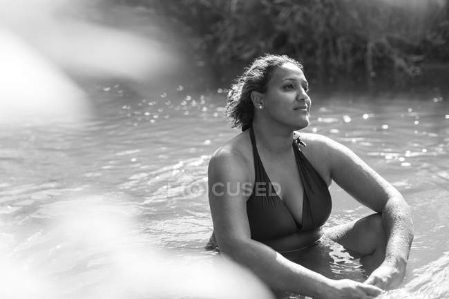 Ruhige Frau sitzt im sonnigen Fluss — Stockfoto