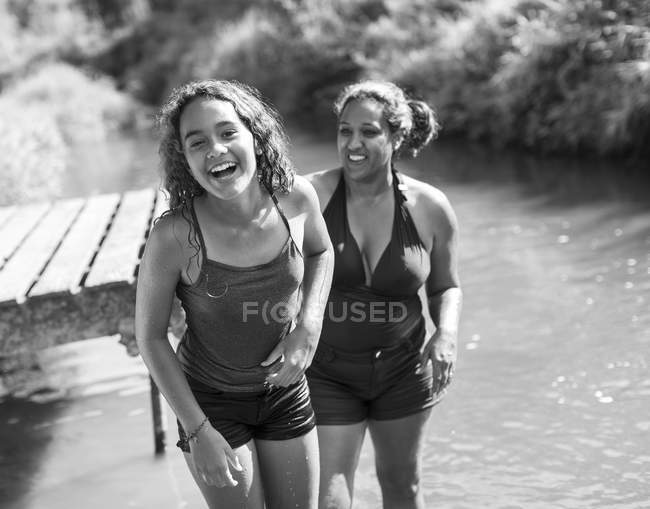 Ritratto felice madre e figlia nuotare nel fiume soleggiato — Foto stock