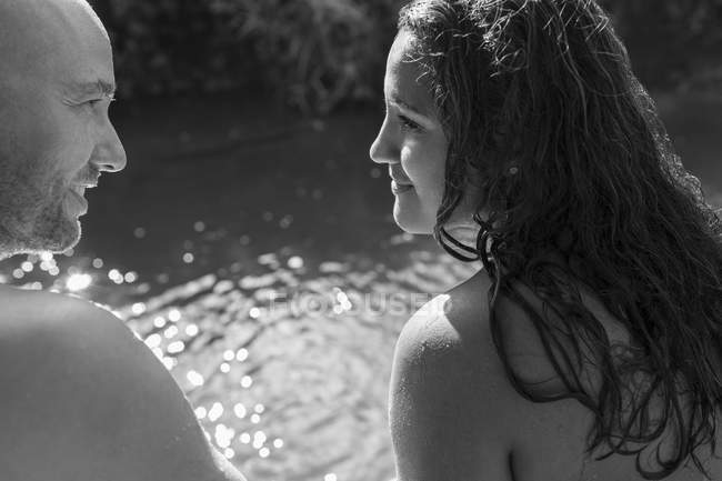 Couple au bord de la rivière ensoleillée, image en noir et blanc — Photo de stock