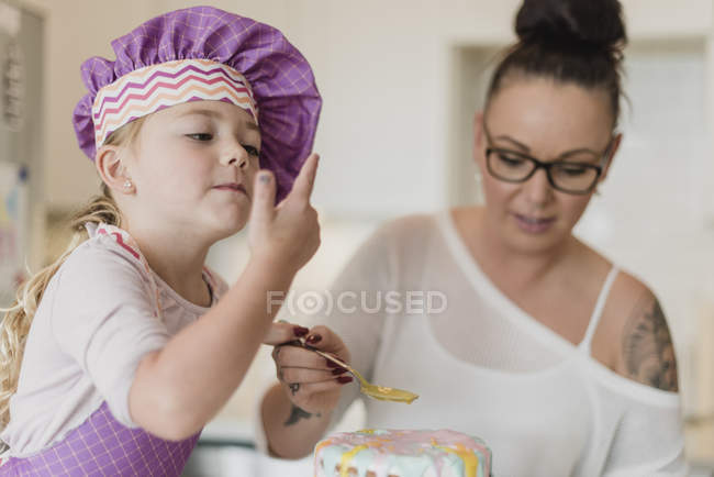 Мати і дочка прикрашають торт — стокове фото