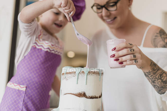 Мати і дочка прикрашають торт — стокове фото
