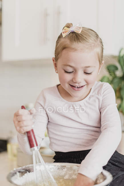 Девочка печет на кухне в помещении — стоковое фото