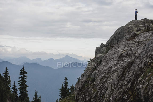 Escursionista maschio in piedi sulla cima robusta della montagna, guardando la vista, Dog Mountain, BC, Canada — Foto stock