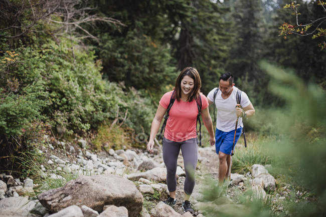 Couple hiking over rocks in woods — Stock Photo