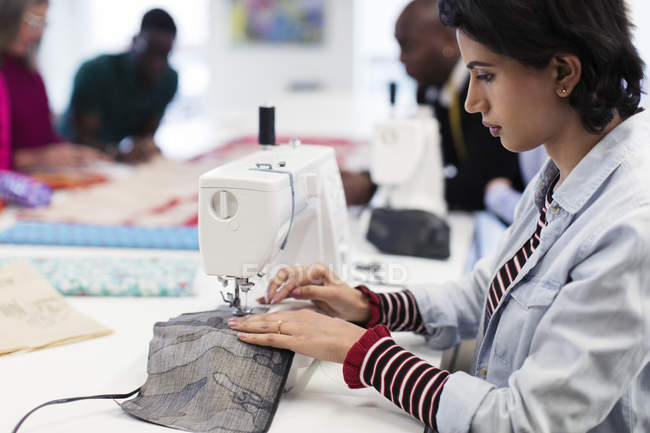 Focada designer de moda feminina usando máquina de costura — Fotografia de Stock