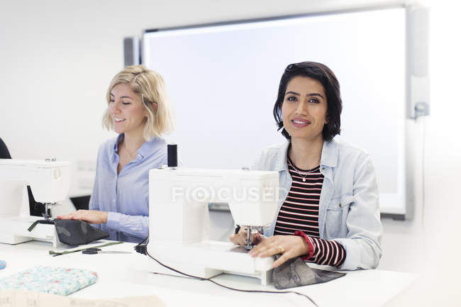 Portrait confident women at sewing machine enjoying sewing class — Stock Photo