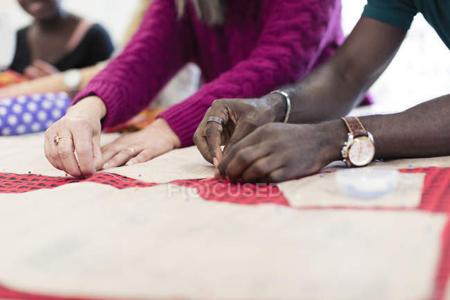 Fashion designers pinning sewing pattern — Stock Photo