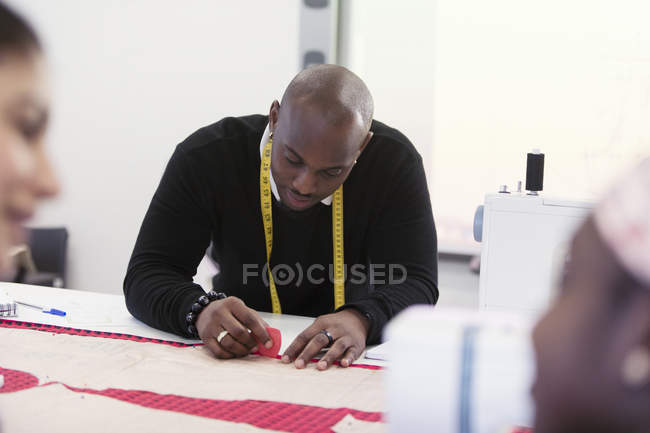 Focused male fashion designer marking sewing pattern — Stock Photo