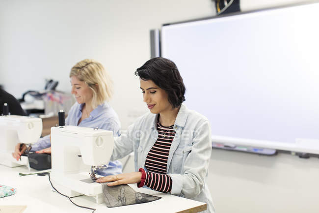 Женщины используют швейную машинку в классе шитья — стоковое фото