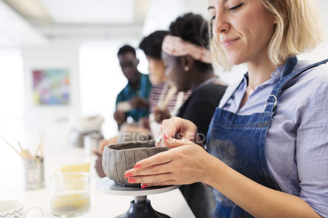Women shaping clay bowl in art class — Stock Photo