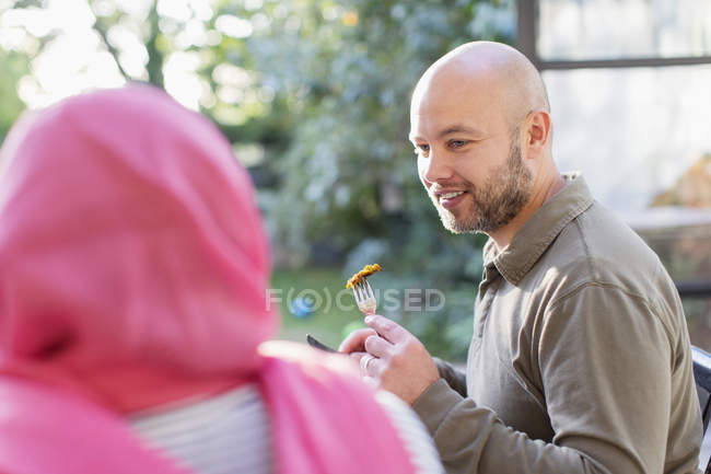 Homem comendo com esposa no hijab — Fotografia de Stock