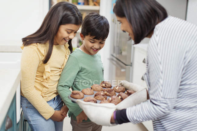Mãe e crianças assar muffins de chocolate — Fotografia de Stock