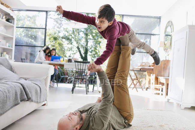 Отец и сын играют на полу в гостиной — стоковое фото