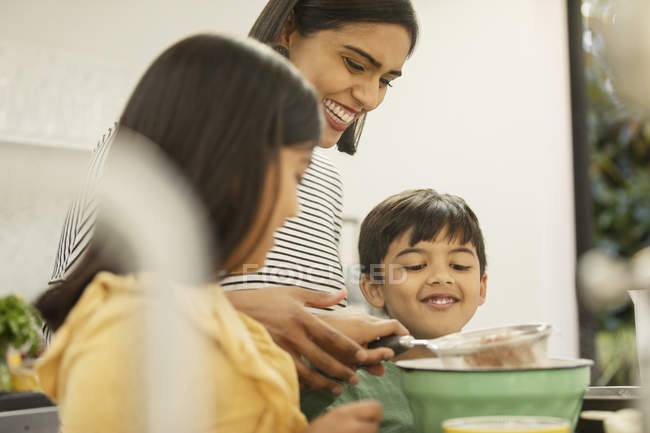 Mother and children baking in kitchen — Stock Photo