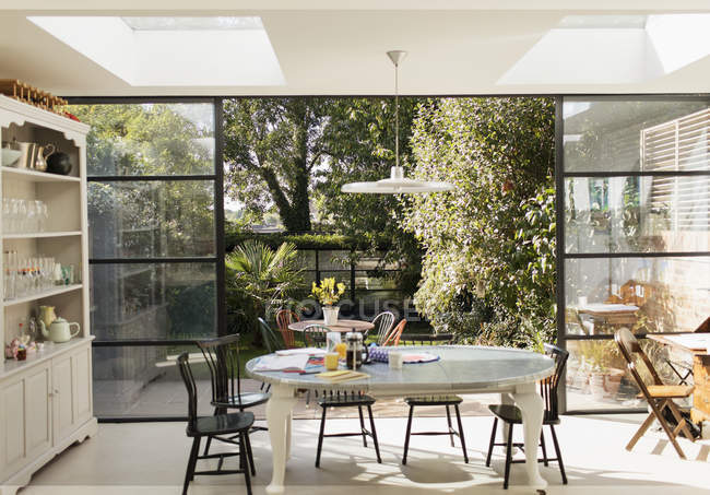 Кухонный стол и двери патио открыты для солнечного сада — стоковое фото