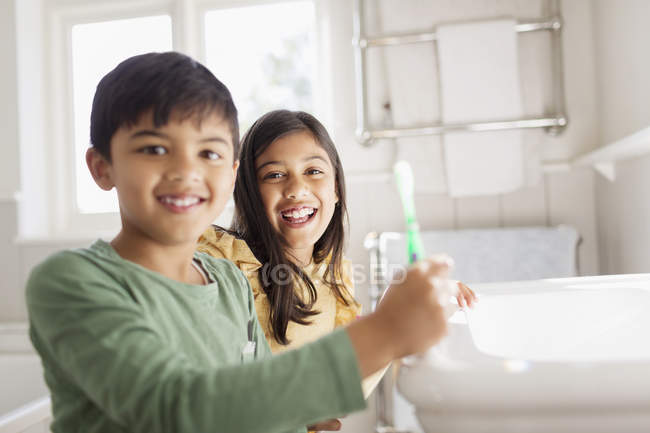 Retrato feliz irmão e irmã escovar os dentes no banheiro — Fotografia de Stock