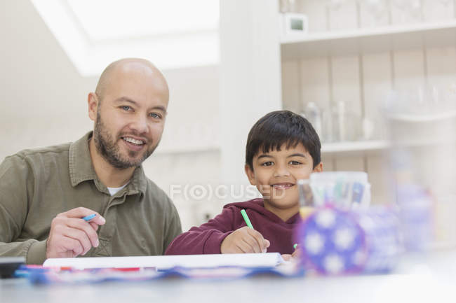 Portrait happy father and son coloring at table — Stock Photo