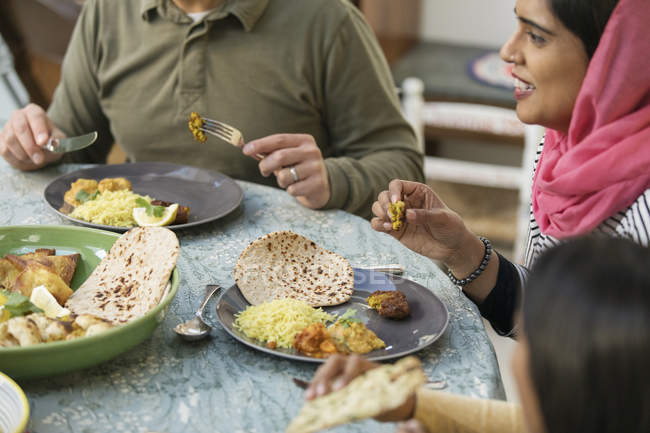 Жінка в хіджабі їсть вечерю з сім'єю за столом — стокове фото