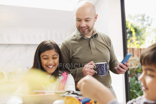 Pai e filha usando tablet digital e telefone inteligente — Fotografia de Stock