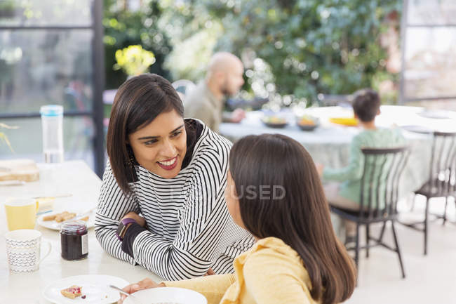 Madre e hija hablando, desayunando - foto de stock