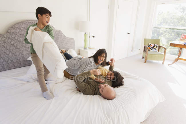 Bonne bataille d'oreillers de famille sur le lit — Photo de stock