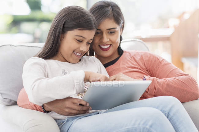 Счастливая мать и дочь с помощью цифрового планшета — стоковое фото