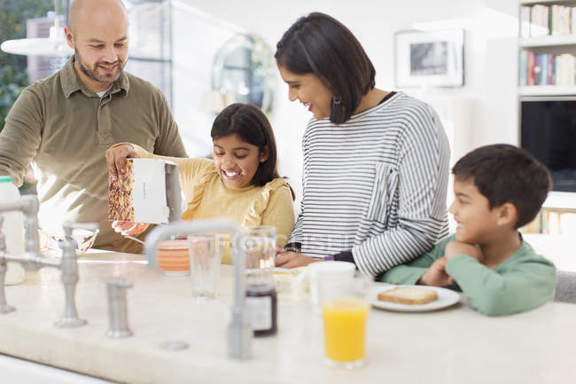 Familia disfrutando del desayuno en la cocina - foto de stock