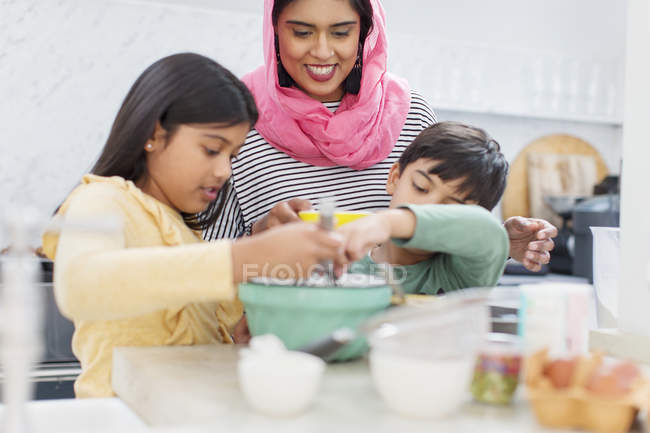 Mãe em hijab assar com crianças na cozinha — Fotografia de Stock