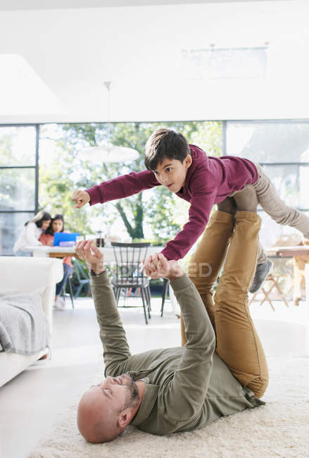 Padre e hijo jugando en el piso de la sala - foto de stock