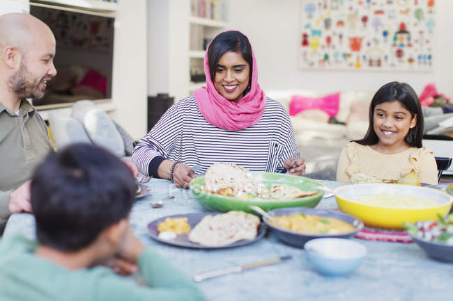 Mutter im Hijab genießt Abendessen mit Familie am Tisch — Stockfoto