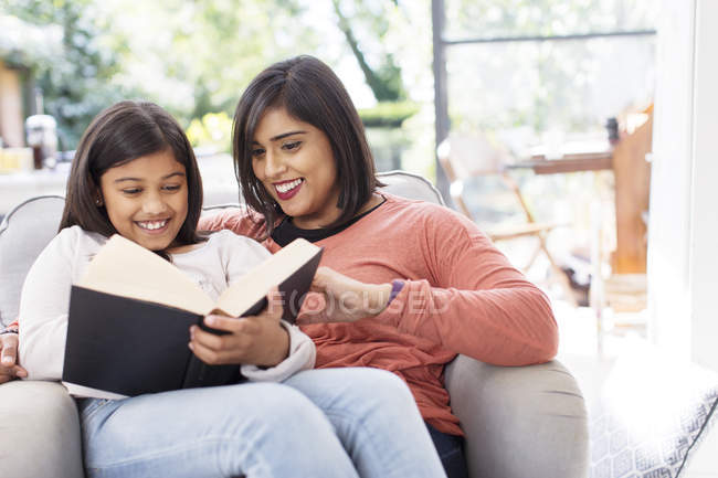 Mutter und Tochter lesen Buch im Sessel — Stockfoto