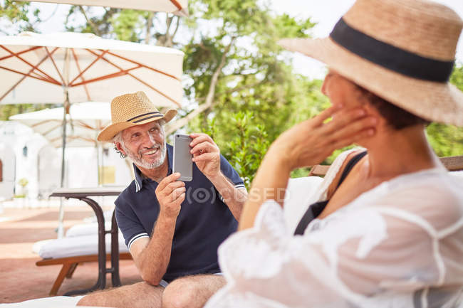 Чоловік з фотоапаратом фотографує дружину біля басейну — стокове фото