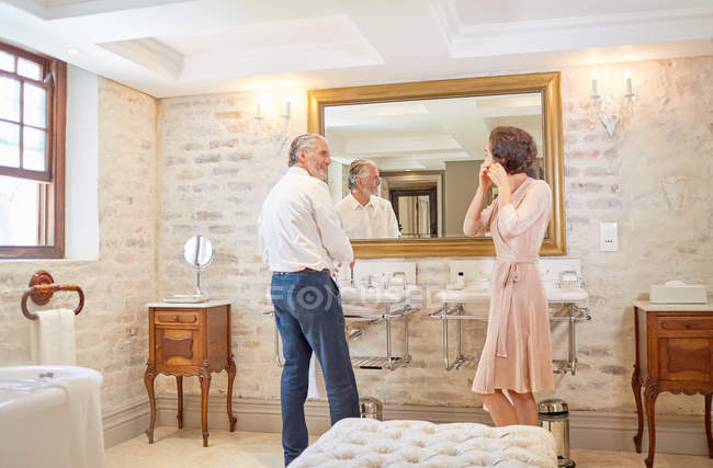 Couple getting ready at hotel bathroom mirror — Stock Photo