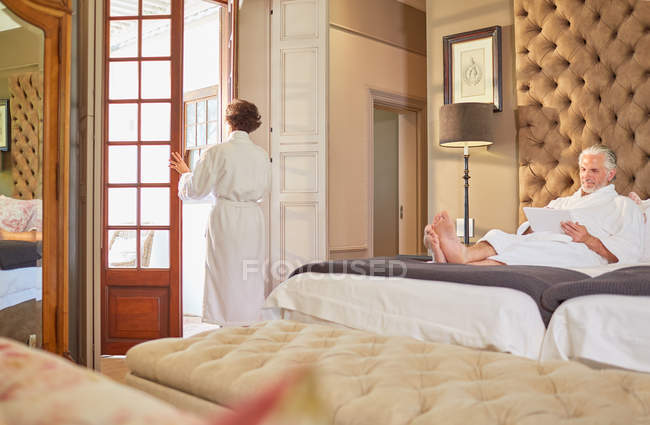 Couple in bathrobes relaxing in hotel room — Stock Photo