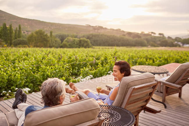 Couple relaxant, buvant du vin sur le patio idyllique, station rurale — Photo de stock