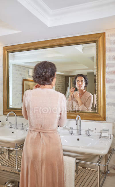 Woman getting ready at hotel bathroom mirror — Stock Photo