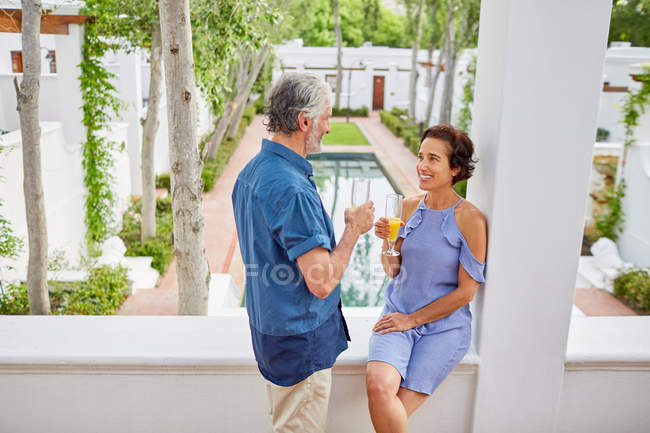 Reifes Paar trinkt Mimosen auf Hotelbalkon — Stockfoto