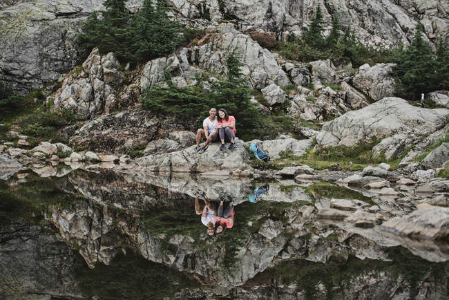 Portrait couple hiking, resting at rocky lake, Dog Mountain, BC, Canada — Stock Photo