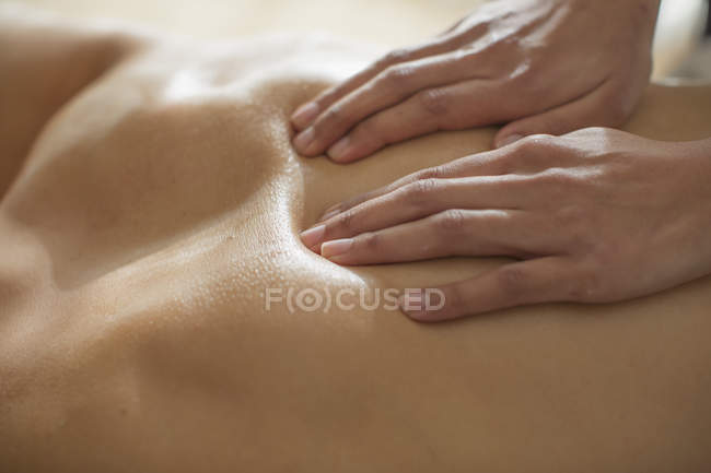 Fechar mulher massageando homem? s de volta — Fotografia de Stock