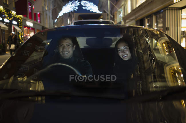 Casal sorridente carro de condução à noite — Fotografia de Stock