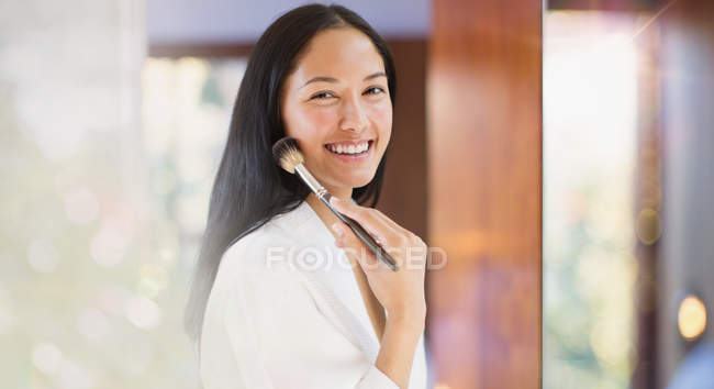 Portrait confident young woman applying makeup — Stock Photo