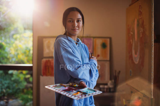 Retrato confiado pintura artista femenina en el estudio de arte - foto de stock
