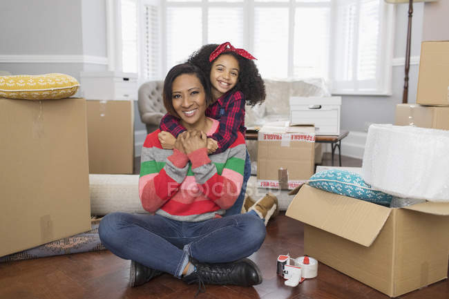 Retrato feliz mãe e filha abraçando, movendo-se para casa nova — Fotografia de Stock