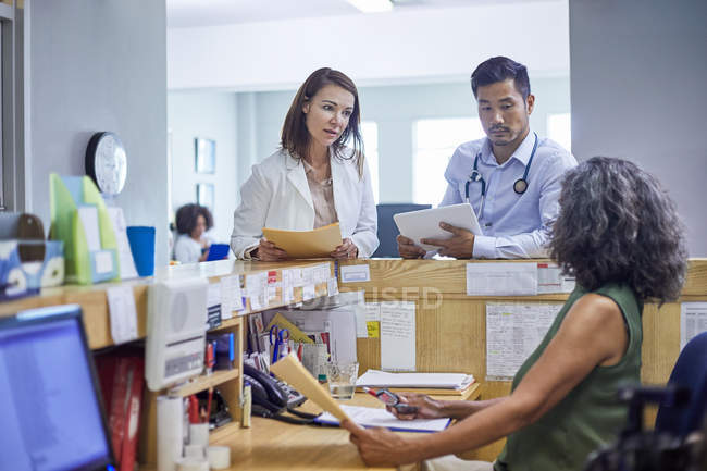 Doctors and receptionist talking in clinic — Stock Photo