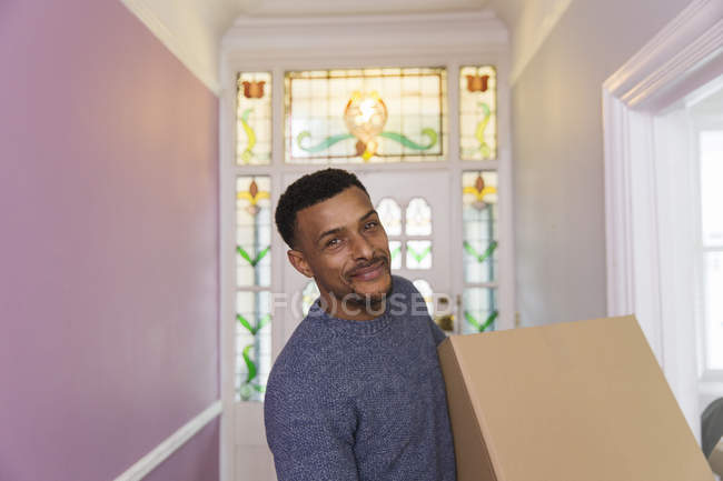 Портрет улыбающийся, уверенный в себе мужчина переезжает в новый дом — стоковое фото