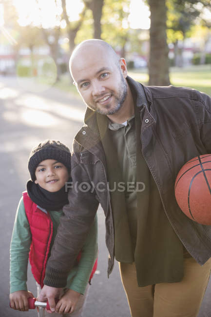 Retrato padre e hijo con baloncesto en el parque de otoño - foto de stock