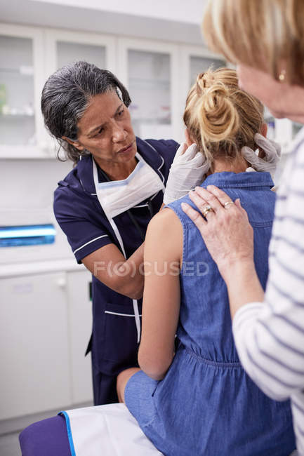 Médico feminino examinando menina paciente na sala de exame — Fotografia de Stock
