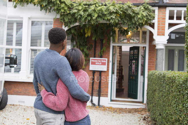 Feliz, casal afetuoso abraçando fora da casa nova — Fotografia de Stock