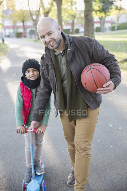 Portrait happy father and son playing in autumn park — Stock Photo